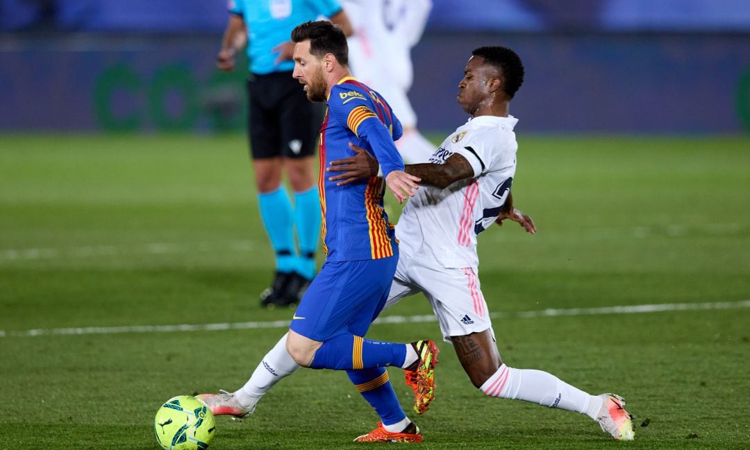 Vinicius intenta robar un balón a Messi en El Clásico