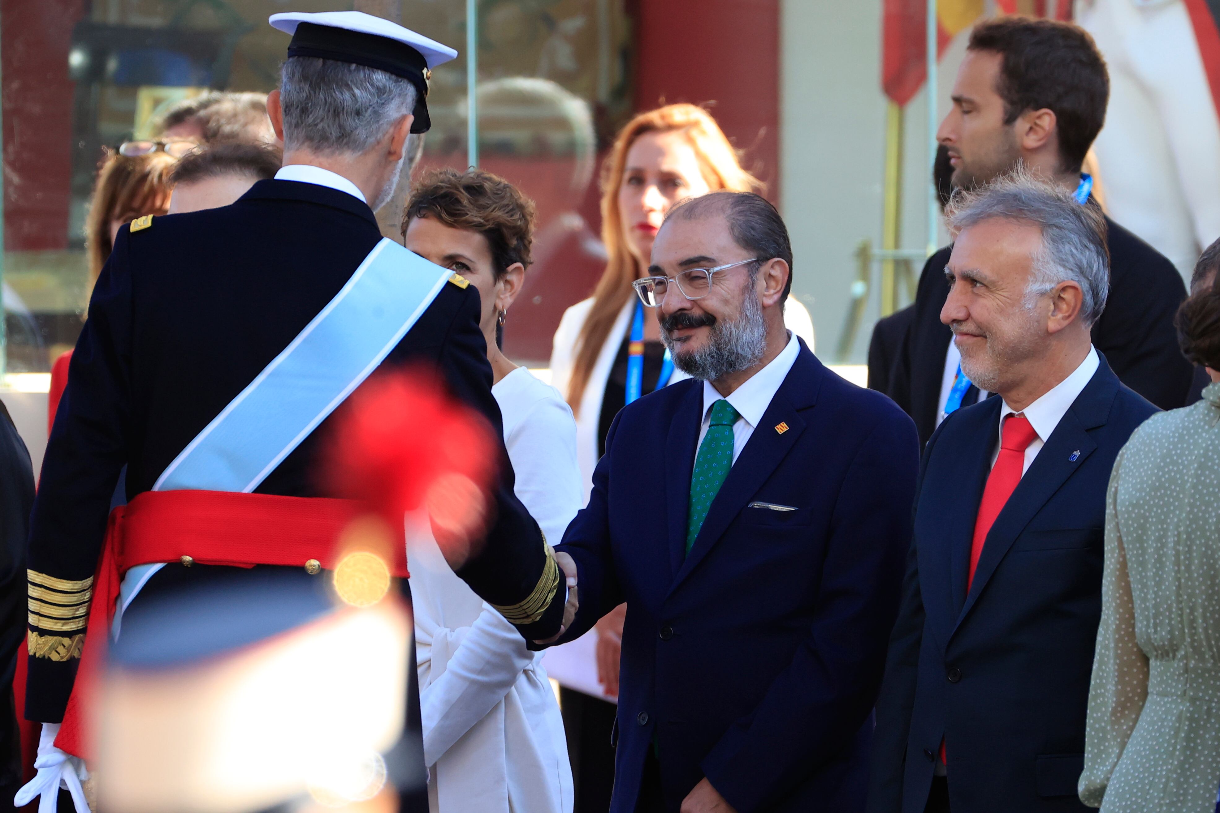 MADRID, 12/10/2022.- El rey saluda al presidente de Aragón, Javier Lambán (c), ante el presidente de Canarias Angel Víctor Torres (d) al inicio del desfile del Día de la Fiesta Nacional, este miércoles, en Madrid. EFE/Zipi Aragón
