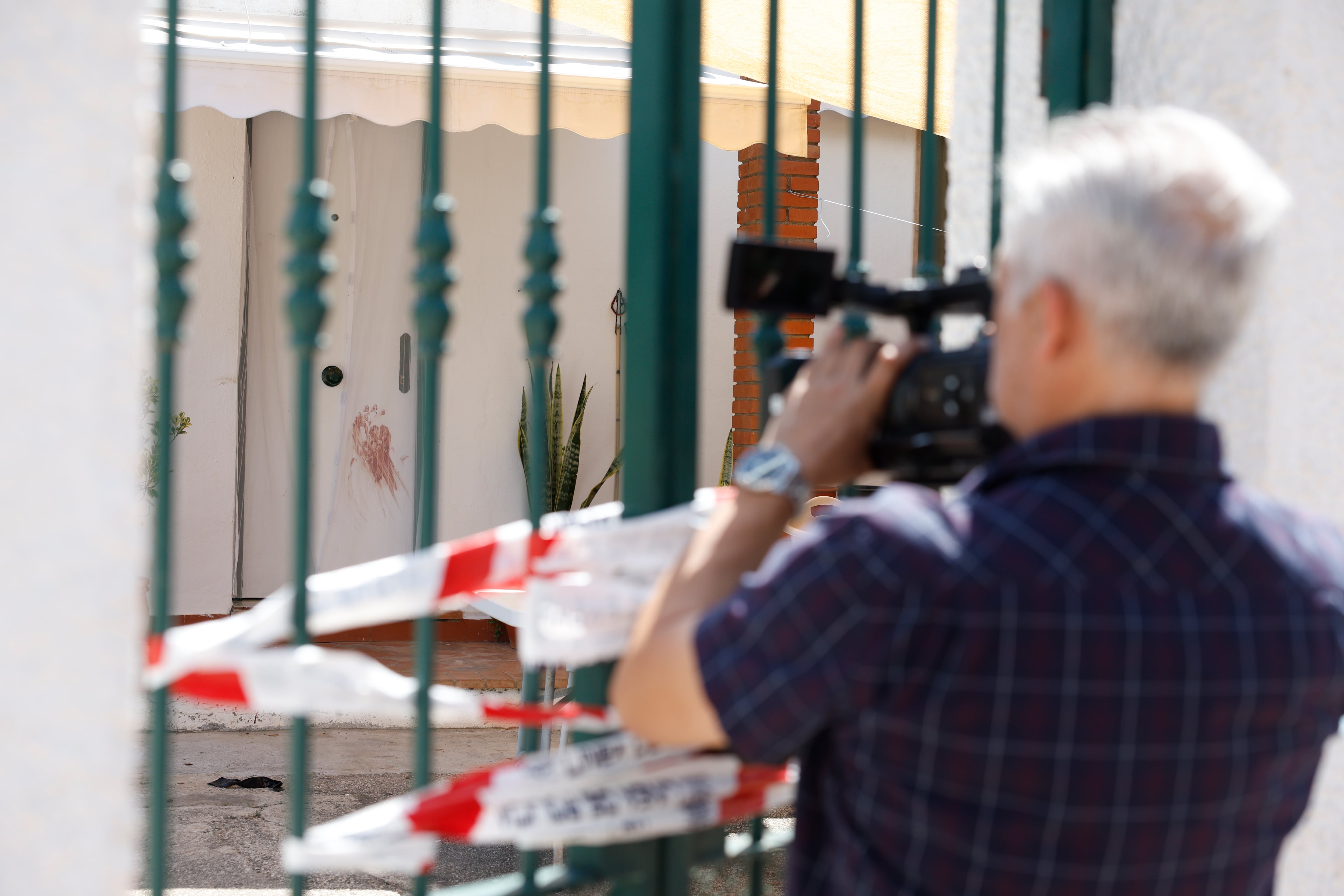 Vélez-Málaga, 31/05/2025.- Un hombre de 70 años ha sido encontrado muerto la noche de este viernes con signos de violencia en Vélez-Málaga (Málaga), y han detenido a su hijo, de 45 años. En la imagen, un cámara de televisión toma imágenes de los restos de sangre en la pared. EFE/Jorge Zapata

