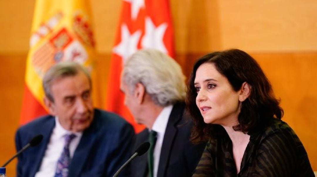 Al fondo, Antonio Burgueño, junto al consejero de Sanidad, Enrique Ruiz Escudero y la presidenta, Isabel Díaz Ayuso