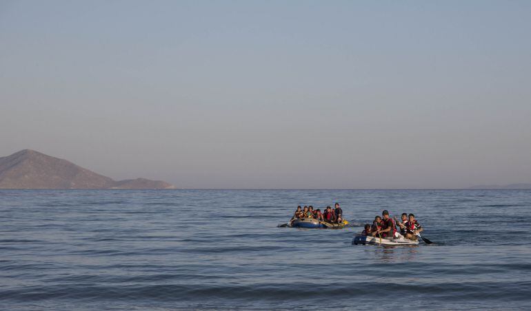 Dos grupos de migrantes llegan a la isla de Kos remando sobre dos barcas de plástico. 