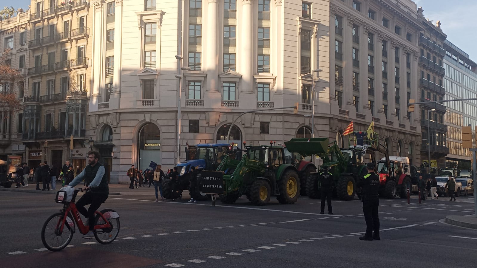 Tractors i bicicleta al carrer Aragó amb passeig de Gràcia, a Barcelona