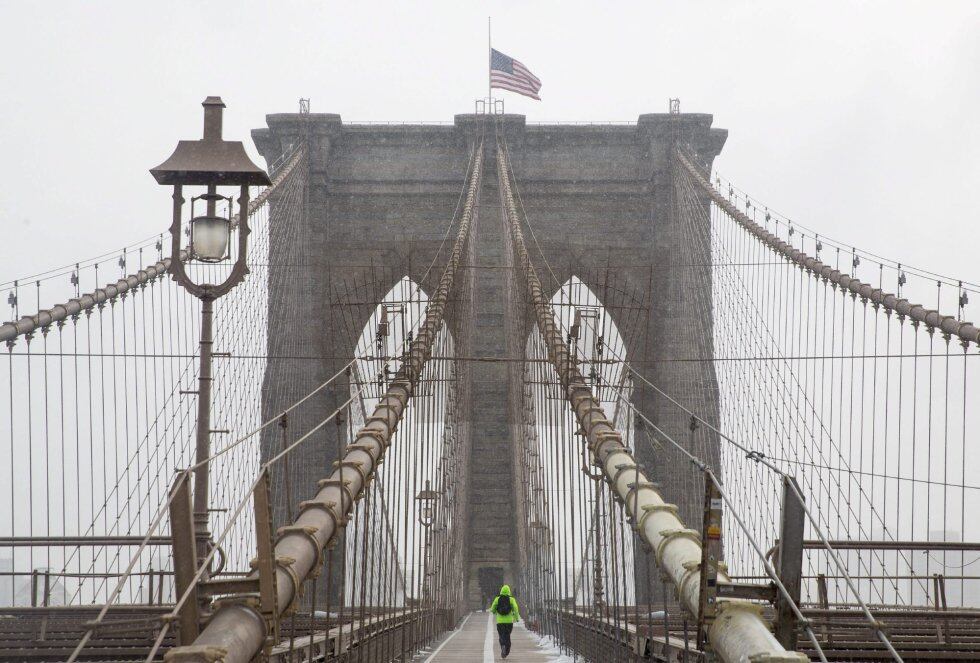 Un hombre atraviesa corriendo el puente de Brooklyn.
