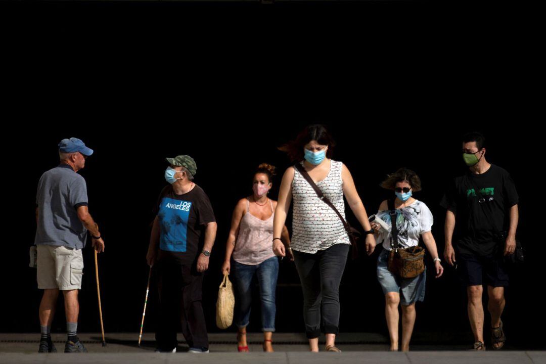 Varias personas en una calle de Barcelona este jueves, el primer día en que es obligatorio el uso de mascarillas en toda Cataluña aunque se puedan guardar las distancias