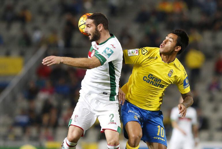 El delantero argentino de la UD Las Palmas Sergio Araujo (d) lucha el balón con Lombán, defensa del Granada