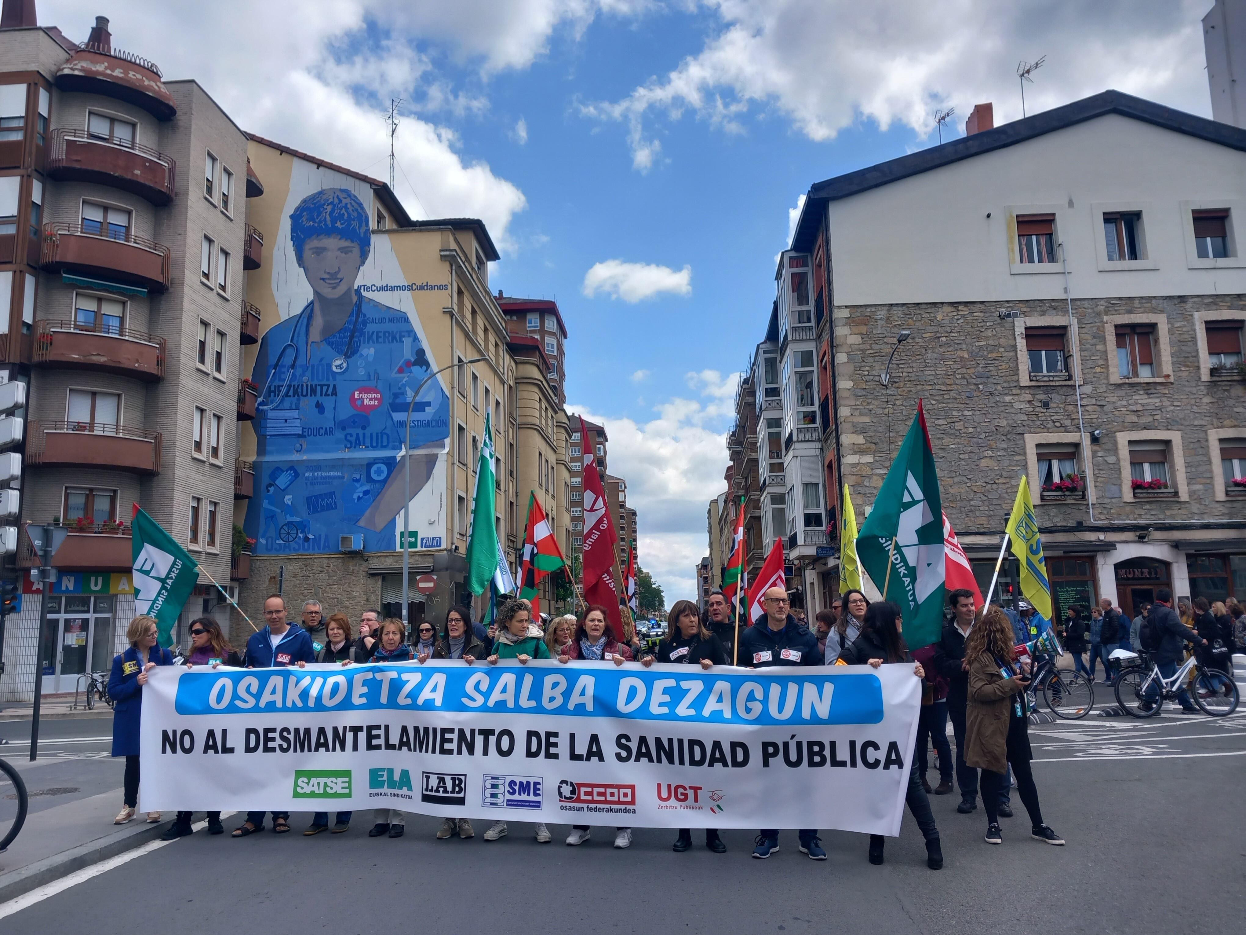 La manifestación se ha detenido ante este gran mural que recuerda el papel de los sanitarios durante la pandemia