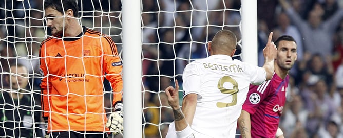 El delantero francés del Real Madrid, Karim Benzema celebra junto a su compañero Sergio Ramos la consecución del primer gol de su equipo con el Olympique de Lyon, en partido correspondiente a la tercera jornada de la fase de grupos de la Liga de Campeones