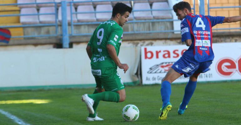 Dos jugadores del Atlético Mancha Real y del Extremadura se disputan el balón.