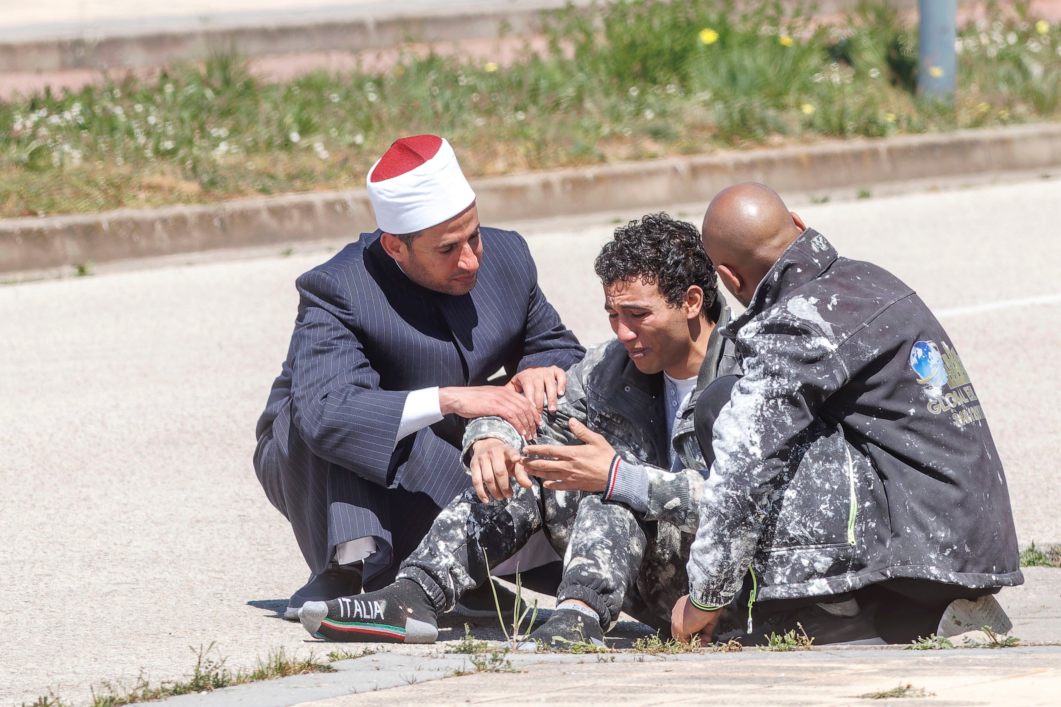 Uno de los dos trabajadores que se han encaramado a una grúa para exigir el pago de sus salarios en Burgos (c) junto al Imán de Burgos y a un compañero de trabajo. Dos trabajadores de la construcción que se encaramaron este sábado a una grúa, a unos cuarenta metros del suelo, para exigir el pago de sus salarios, en el barrio Fuentecillas de Burgos, han depuesto ya su actitud y han abandonado el lugar en un coche policial. EFE/Santi Otero