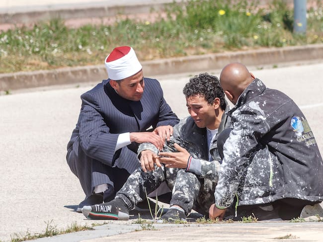 Uno de los dos trabajadores que se han encaramado a una grúa para exigir el pago de sus salarios en Burgos (c) junto al Imán de Burgos y a un compañero de trabajo. Dos trabajadores de la construcción que se encaramaron este sábado a una grúa, a unos cuarenta metros del suelo, para exigir el pago de sus salarios, en el barrio Fuentecillas de Burgos, han depuesto ya su actitud y han abandonado el lugar en un coche policial. EFE/Santi Otero