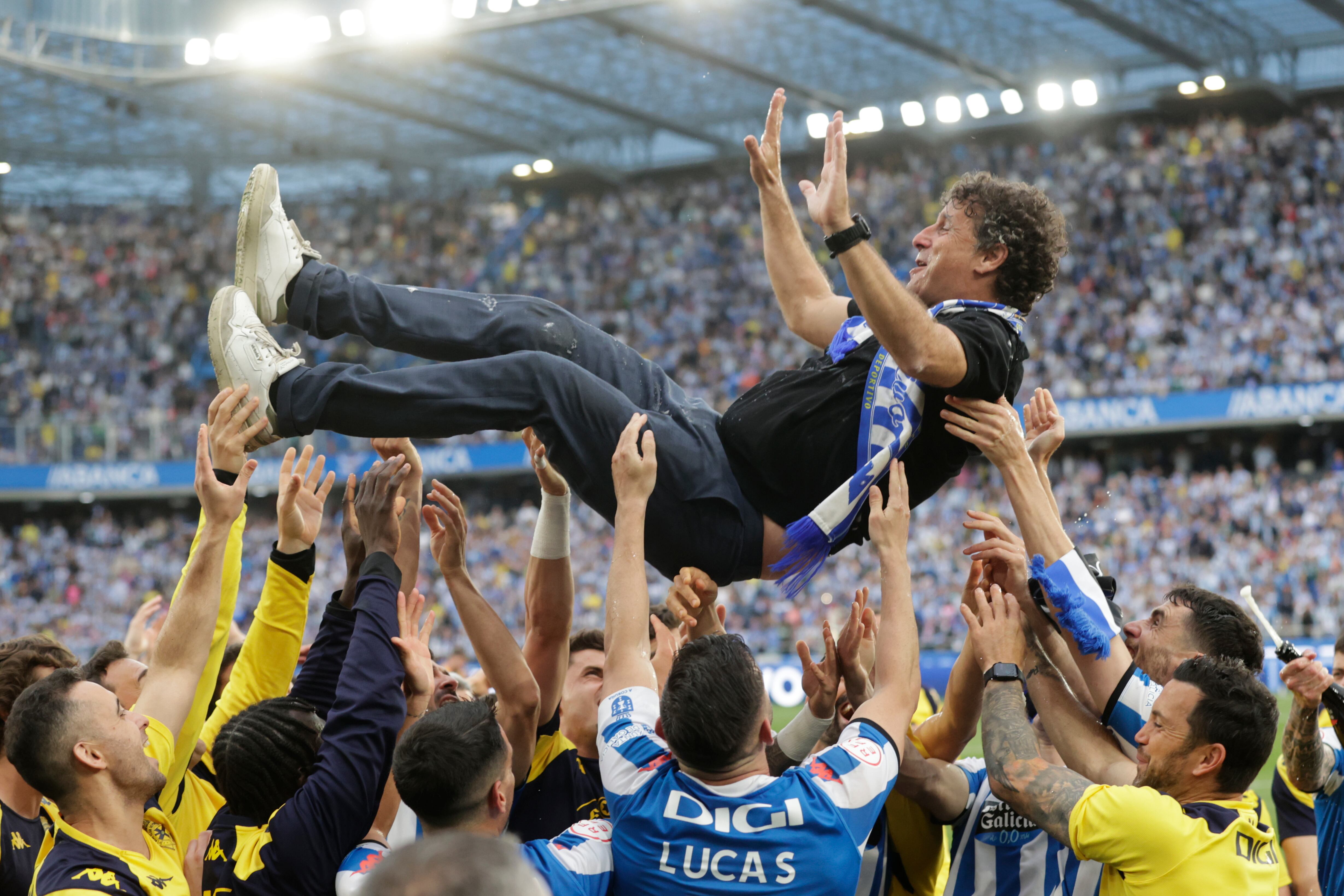 A CORUÑA, 12/05/24.- Los jugadores del Deportivo mantean al entrenador, Imanol Idiáquez (c), durante la celebración del ascenso a Segunda División tras vencer al Barça Atlètic este domingo en el estadio de Riazor de A Coruña. EFE/Cabalar