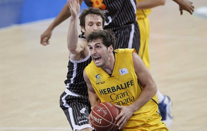 El base del Herbalife Gran Canaria, Tomás Bellas, controla el balón bajo la presión del base del Uxue Bilbao Basket Raúl López durante el partido de cuartos de final de la Copa del Rey de baloncesto.