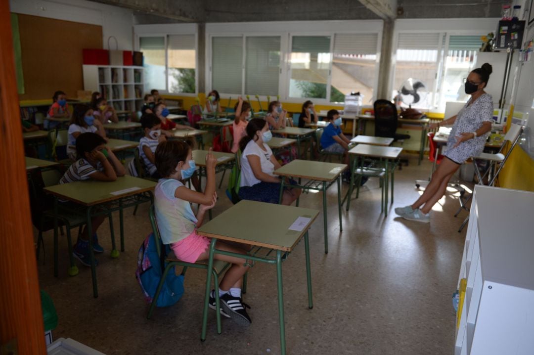 Foto de archivo del aula de un colegio con todos los alumnos y la docente con la mascarilla puesta