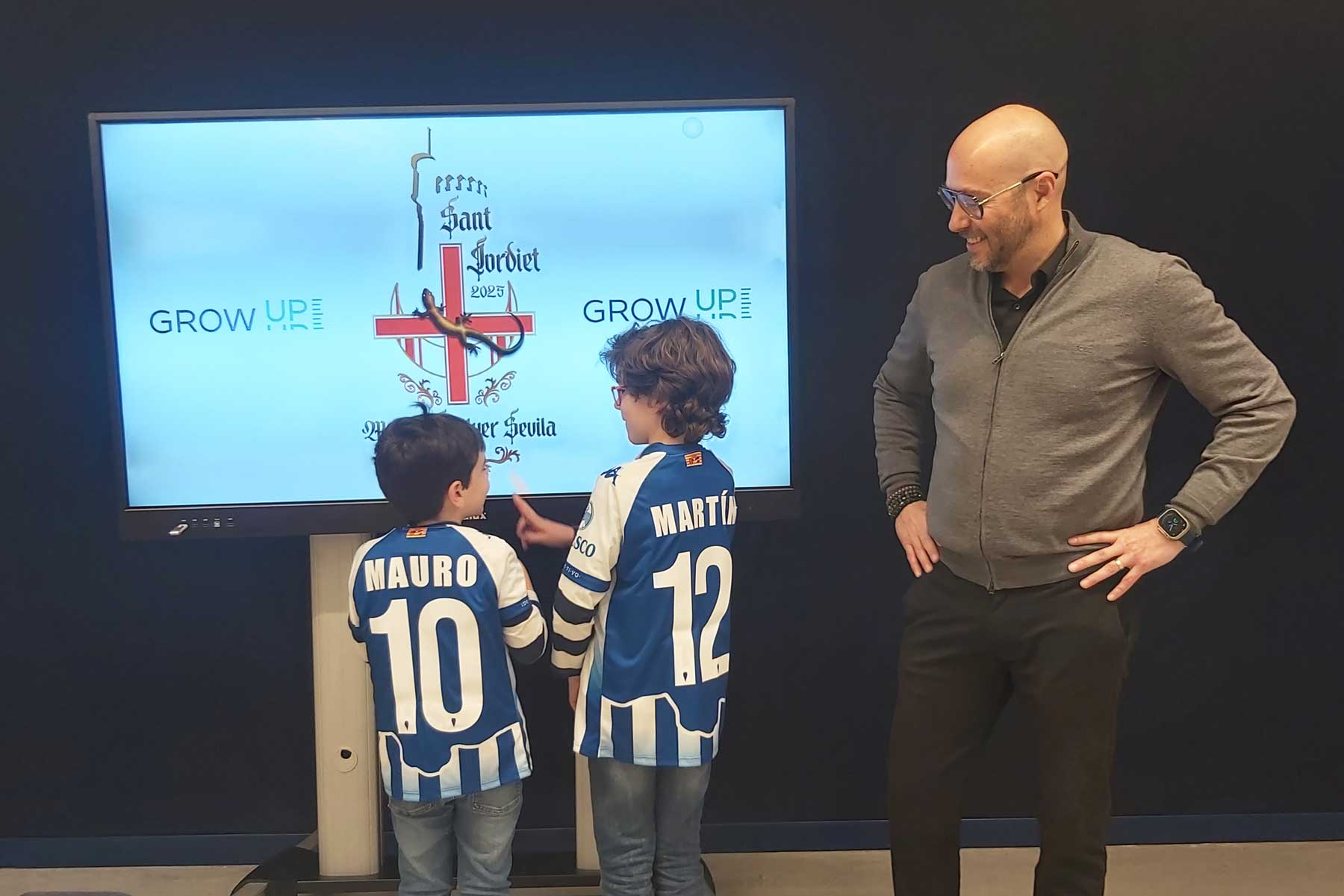 Miguel Ángel Llorens observa al Sant Jordiet, Martín y su hermano Mauro, con sus camisetas personalizadas