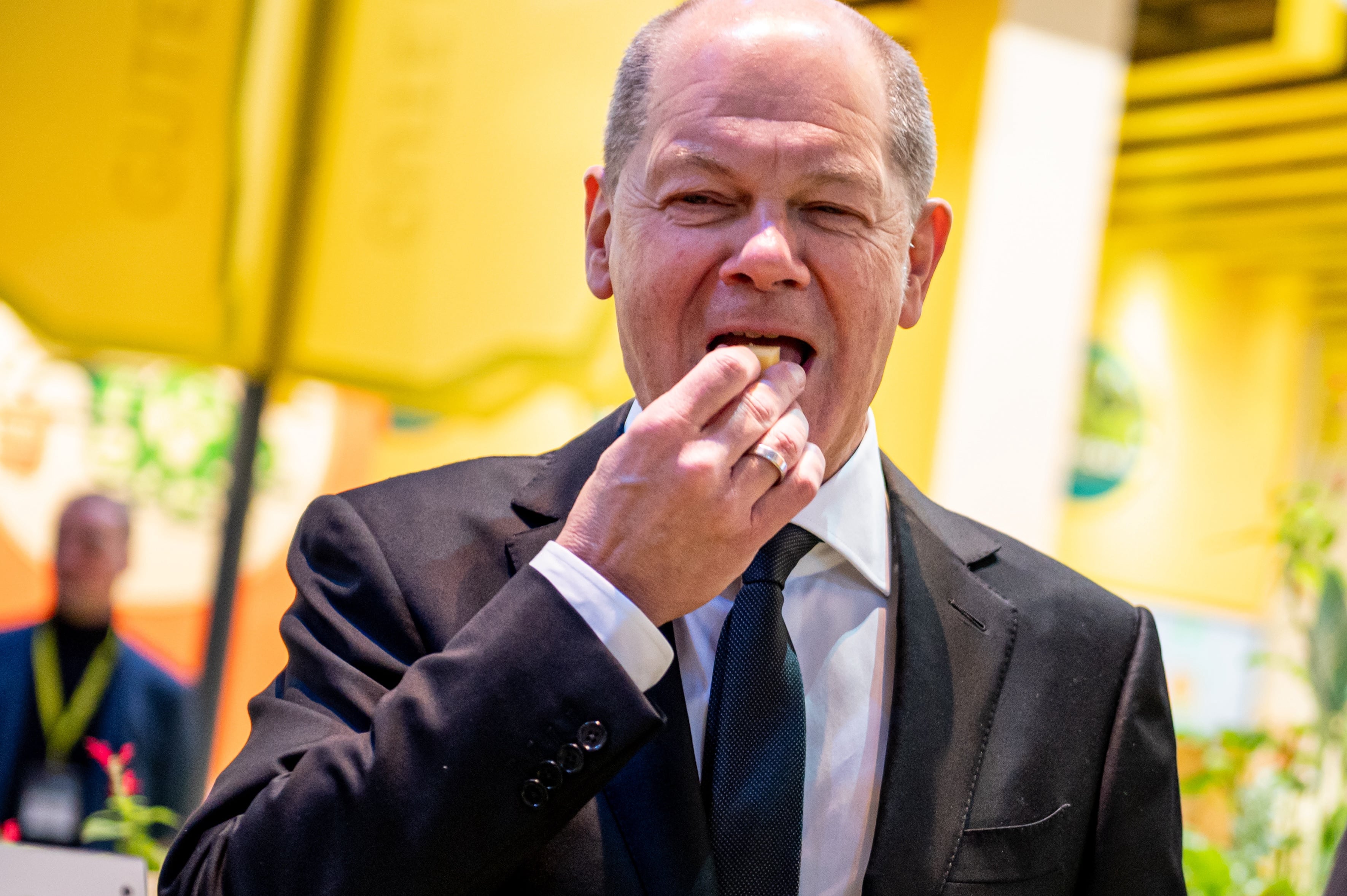 El canciller alemán Olaf Scholz comiendo un trozo de queso en un evento este año en Berlín