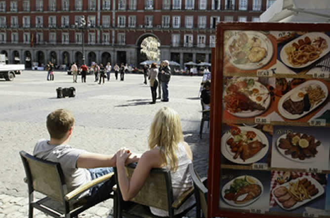 Turistas descansando en la Plaza Mayor de Madrid.