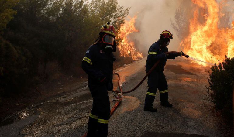 Bomberos tratan de extinguir un incendio en Penteli, al norte de Atenas (Grecia).