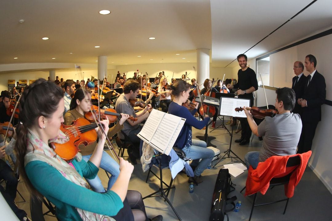 El director artístio del Adda, con jóvenes de la Orquesta y el presidente de la Diputación, César Sánchez, al fondo.