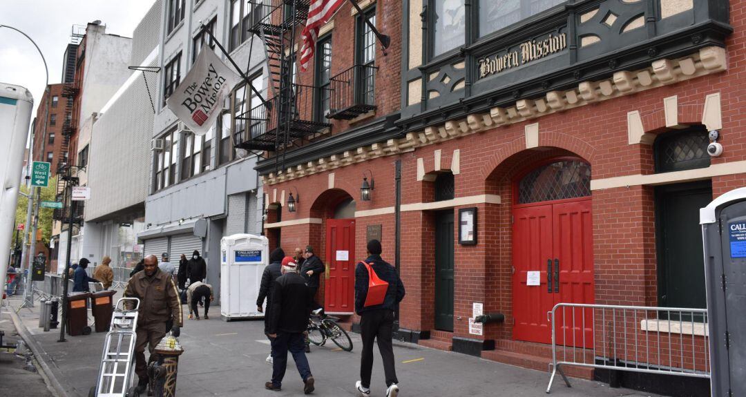 Unas personas caminan frente a la sede del Bowery Mission, una cocina social y albergue auspiciada por la iglesia católica