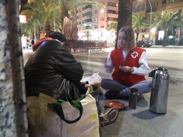 Una voluntaria atiende la pasada noche a una persona que duerme en la calle