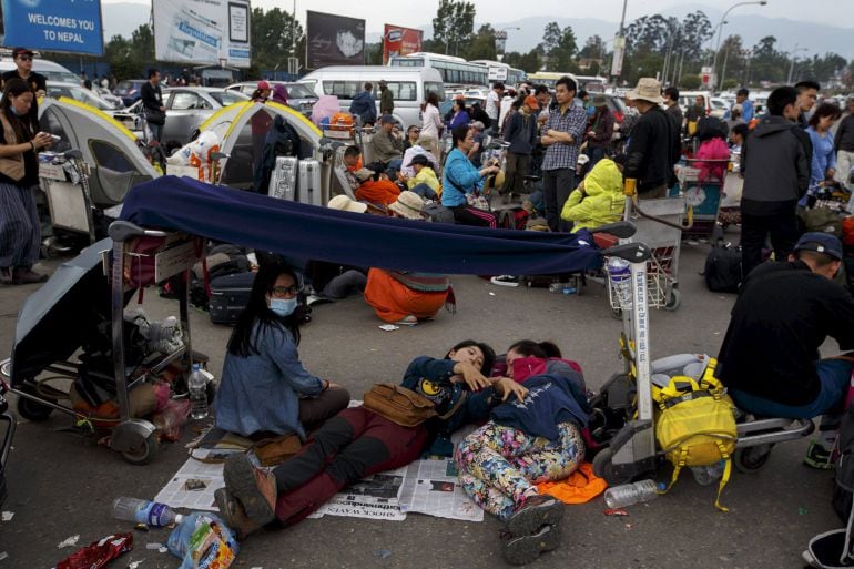 Tourists wait for their flights outside Nepal&#039;s Tribhuvan International Airport a day after a 7.9 magnitude earthquake, in Kathmandu, Nepal April 26, 2015. Rescuers dug with their bare hands and bodies piled up in Nepal on Sunday after the earthquake deva