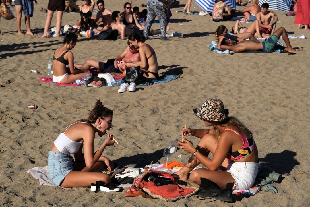 Dos mujeres, en la playa de la Barceloneta (Barcelona), este domingo.