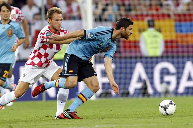 El centrocampista de España, Xabi Alonso (d), pelea un balón con el centrocampista de Croacia Ivan Rakitic, en partido correspondiente a la tercera jornada del Grupo C de la Eurocopa