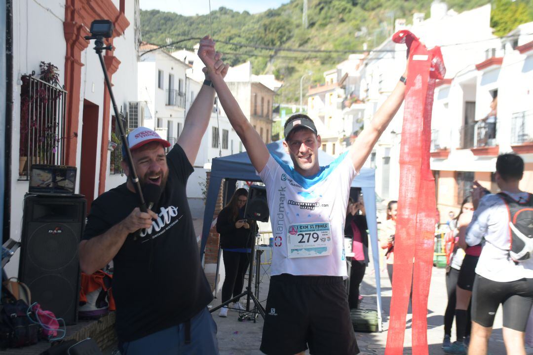 Pedro Chito, speaker oficial de la prueba, junto a uno de los ganadores en su llegada a meta