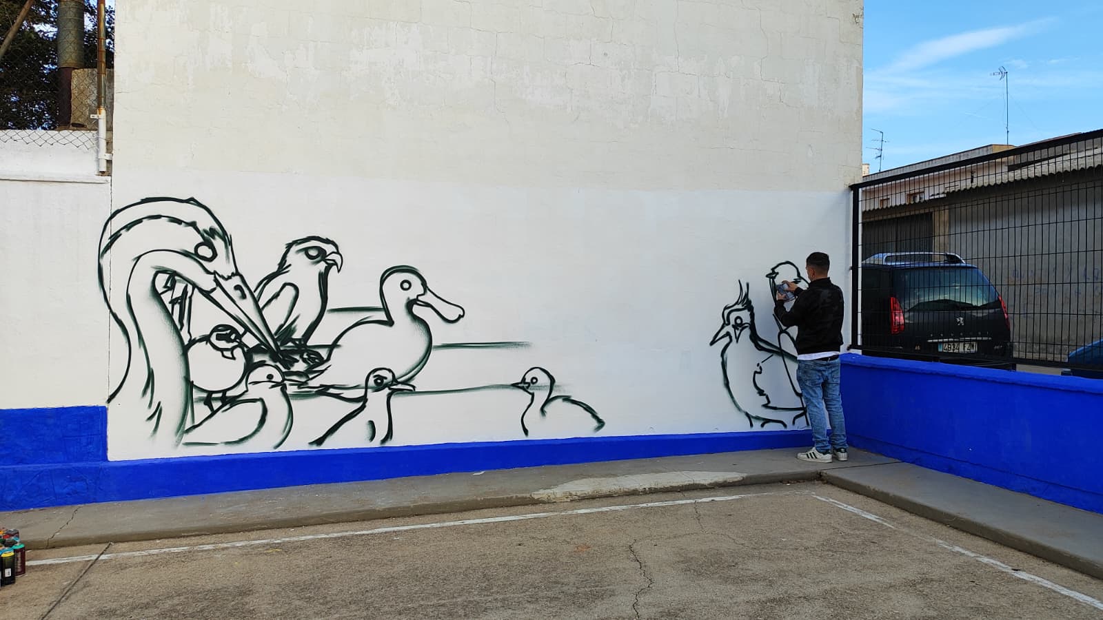Mural sobre medioambiente de ADI El Záncara. El muralista comienza a pintar en el colegio de Las Pedroñeras