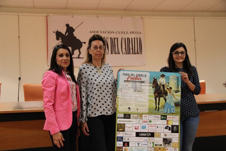 Componentes de la Asociación Cuellarana Amigos del Caballo muestran el cartel de la programación de la Feria 