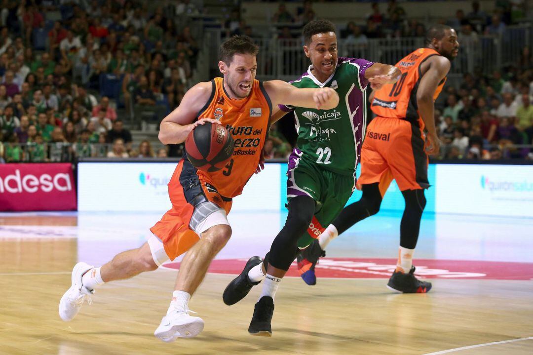 El base del Valencia Basket Sam Van Rossom con el balón ante la defensa del base estadounidense del Unicaja Brian Roberts 