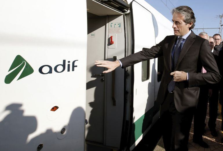 El ministro de Fomento, Íñigo de la Serna, sube al tren en la estación de Sagunto tras realizar el trayecto ferroviario desde Valencia para tratar sobre la necesidad de iniciar las obras del Corredor Mediterráneo