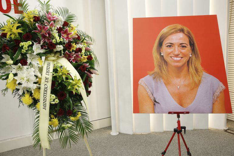 Una corona de flores enviada por el Ministerio de Defensa y un retrato de Carme Chacón, exministra socialista de Defensa y exvicepresidenta primera del Congreso, que falleció ayer en Madrid a los 46 años ,en la sede del PSOE donde ha quedado instalada la 