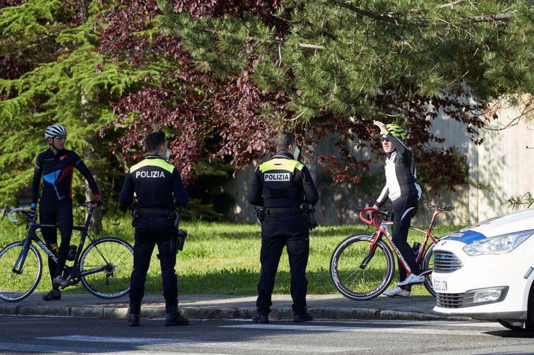 Policías locales dan insrucciones a un par de cliclistas