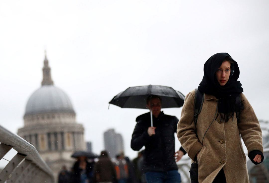 La gente camina en condiciones ventosas a través del Puente del Milenio durante la tormenta &#039;Dennis&#039; en Londres