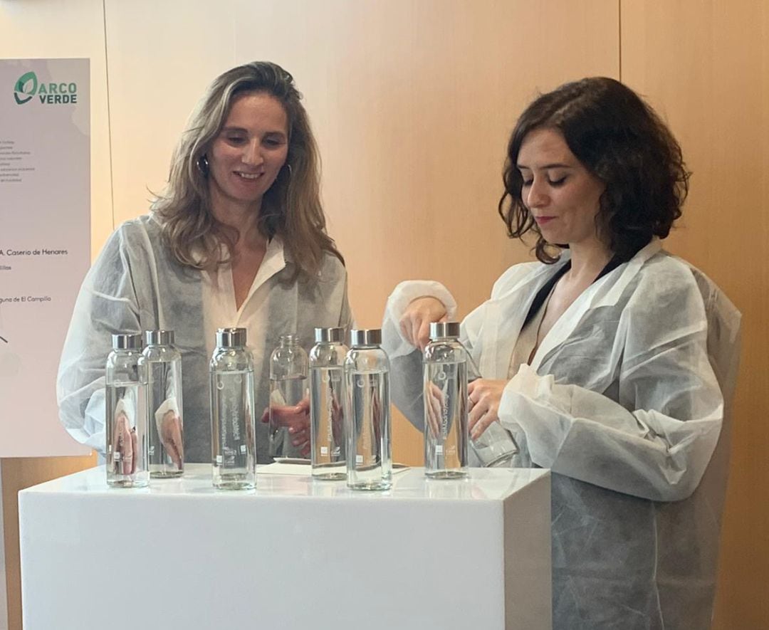 La presidenta Isabel Díaz Ayuso mostrando las botellas que se repartirán a los asistentes a la cumbre