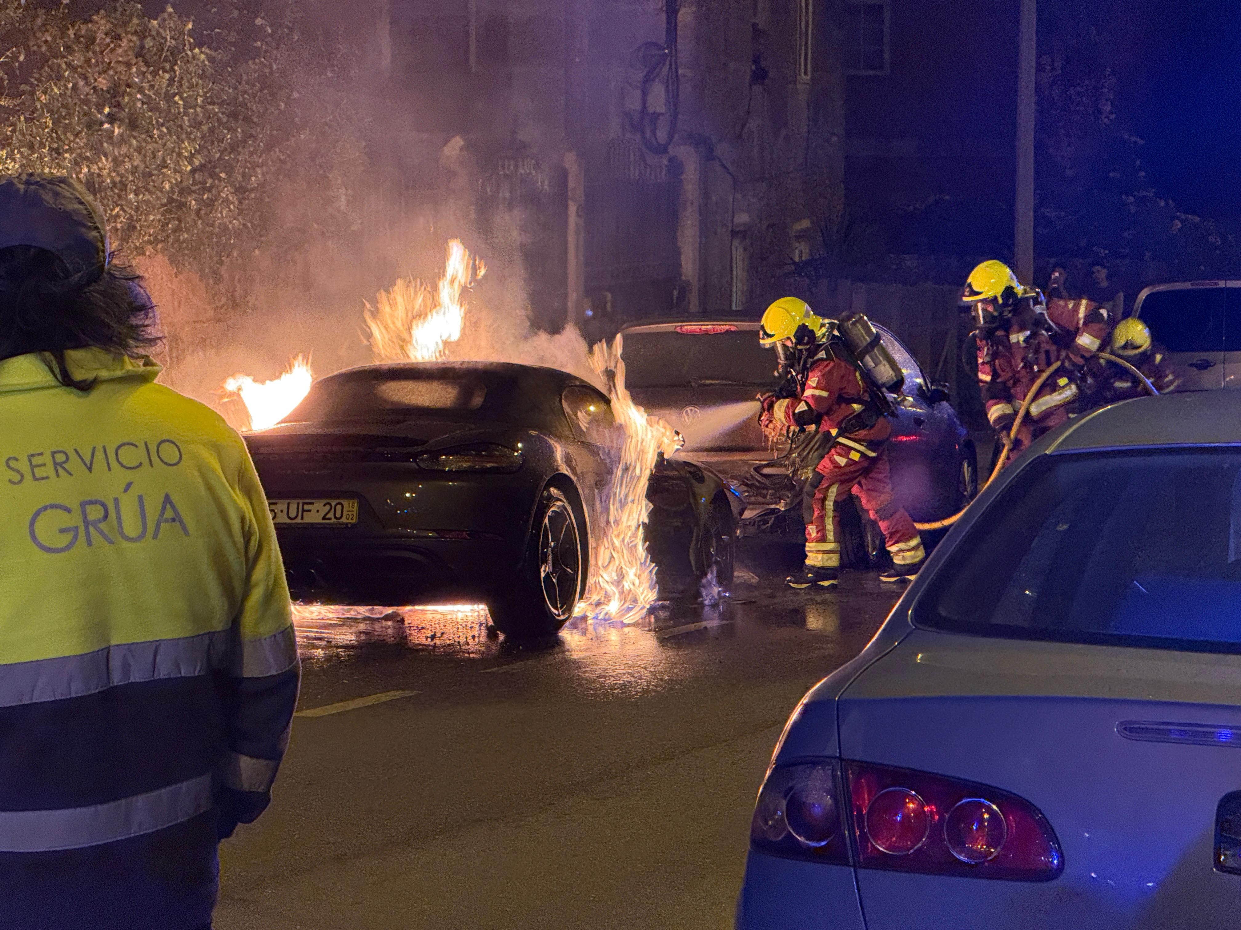 Los bomberos intentan sofocar las llamas en el incendio de un Porsche de matrícula portuguesa aparcado en el centro de Vigo