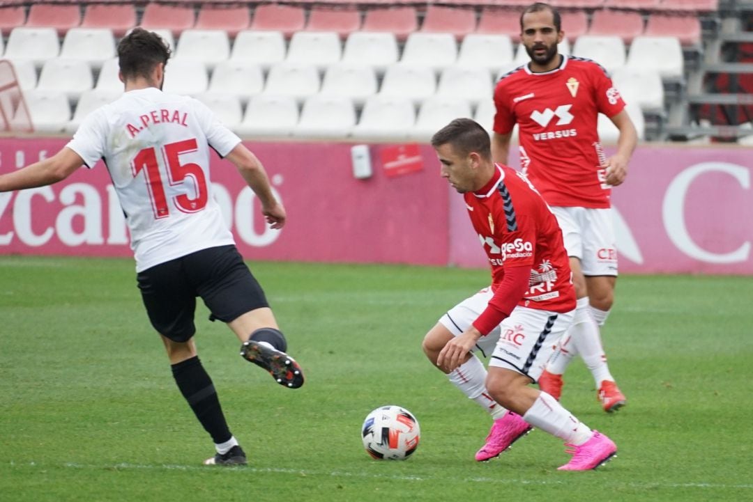 Jesús Carrillo controla un balón ante Adrián Peral y la atenta mirada de Verza