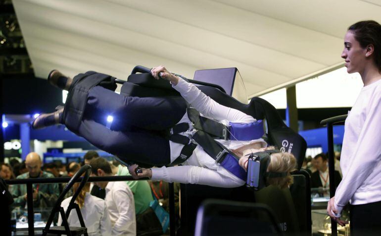 Una visitante prueba un simulador de vuelo acrobático de realidad virtual durante el Mobile World Congress (MWC), la mayor feria de telefonía del mundo, que hoy ha comenzado en Barcelona.