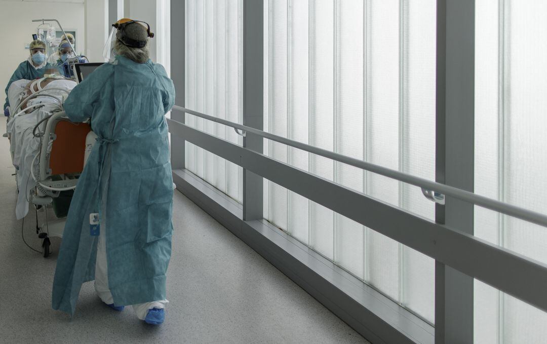 Personal sanitario trasladando a un paciente de la UCI