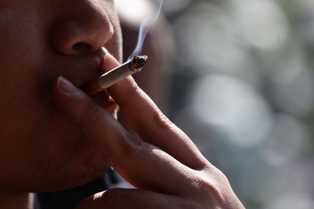 Una persona fuma un cigarrillo en la calle