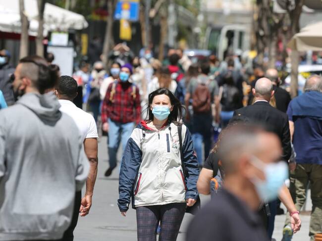 Diverses persones caminen amb mascareta. Des d'aquesta propera mitjanit ja no serà obligatòria portar-la en espais exteriors.
