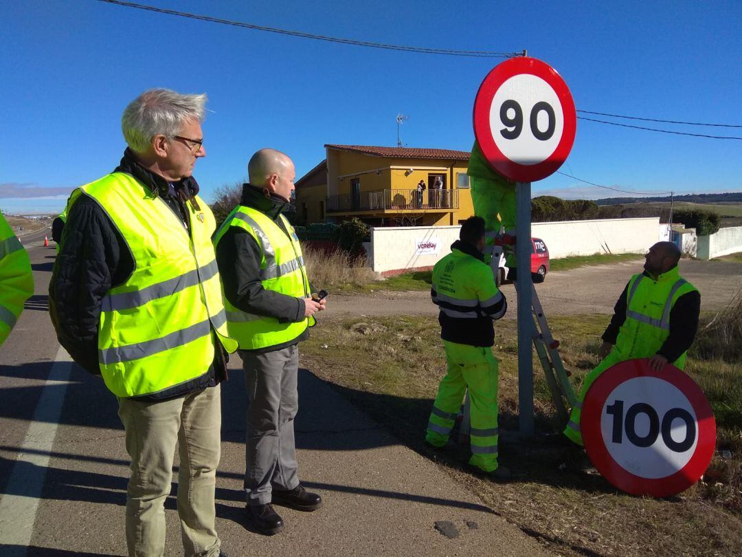 El subdelegado del Gobierno y el responsable de tráfico en Palencia observan la retirada de la última señal que marcaba 100 en carretera convencional