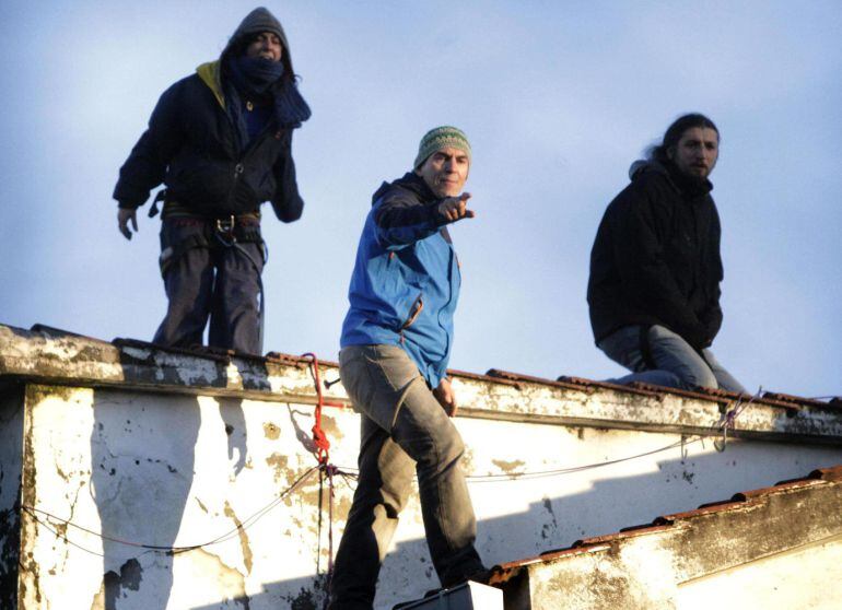 Roberto Rivas (centro), el bombero que se negó a desahuciar a una anciana de A Coruña, y dos activistas de la plataforma Stop Desafiuzamentos encaramados en el tejado la vivienda de Isabel y Álvaro.