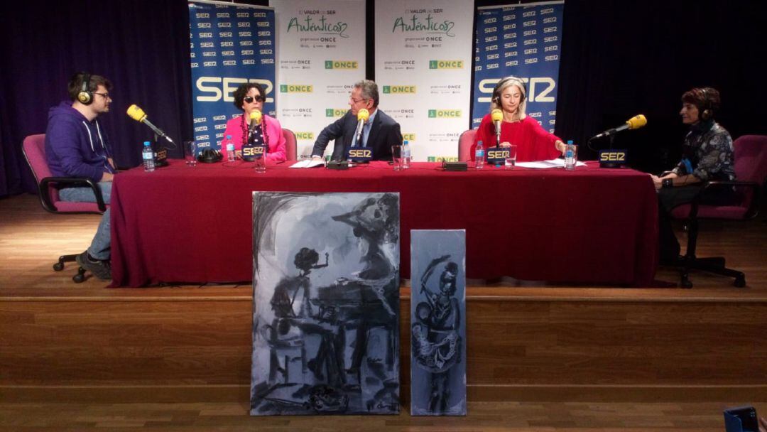 De izquierda a derecha, Fran Heredia, Isabel Viruet, Salomón Hachuel, la consejera Patricia del Pozo y la pintora María José Fernández con dos obras suyas ante el escenario