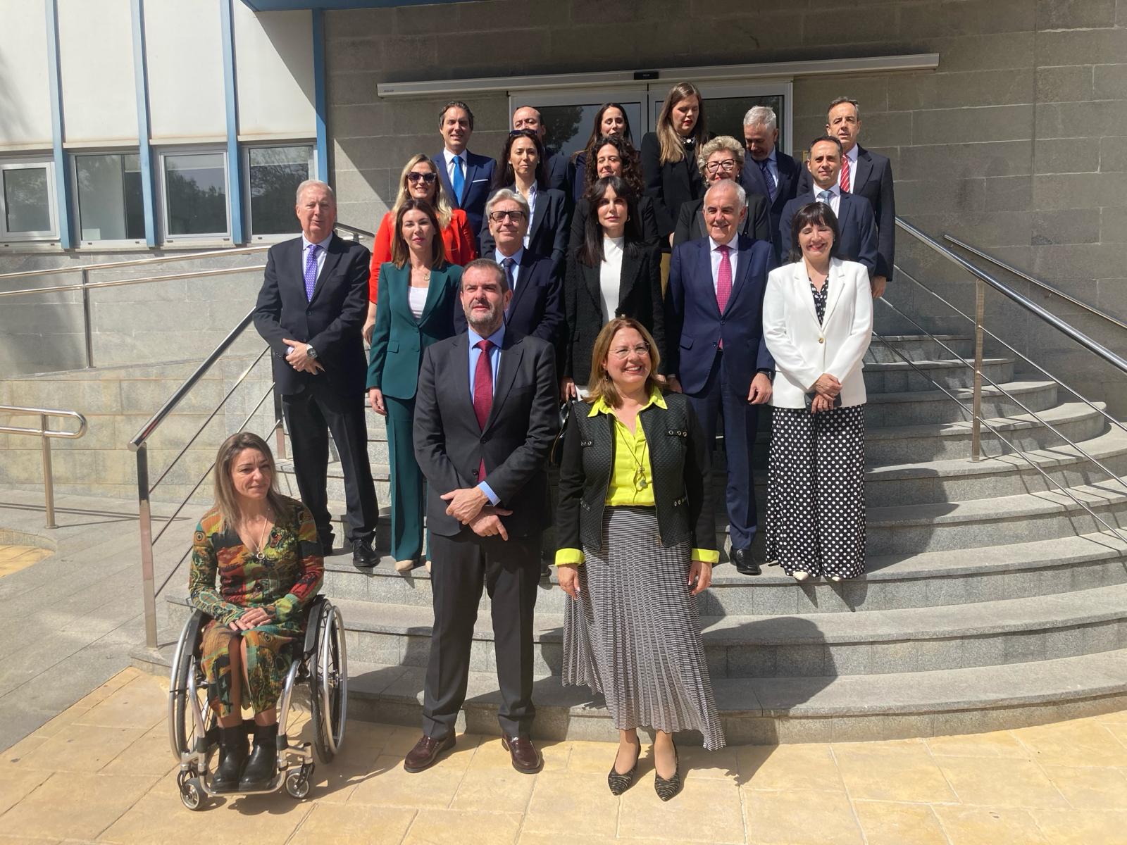 El presidente de Hefame, Enrique Ayuso y la presidenta de la Asamblea Regional, Visitación Martínez, posan para una foto de familia junto a la delegación de diputados regionales que han visitado la sede de Hefame, en Santomera