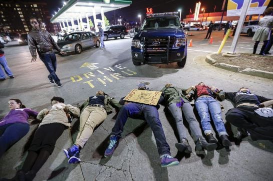 Manifestantes se tumban frente de una gasolinera en Spring Street en protesta contra la decisión del jurado