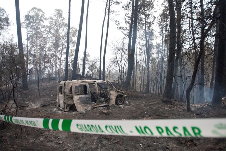 El coche donde fallecieron dos mujeres, víctimas del fuego, en la zona de Chandebrito en Nigrán (Pontevedra). Las altas temperaturas y los fuertes vientos han magnificado el efecto de los incendios en las Rías Bajas, que estos días presentan unas temperaturas veraniegas