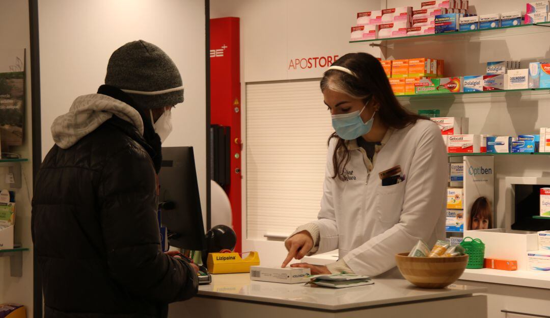 Una empleada vende un test de antígenos en una farmacia de Tarragona