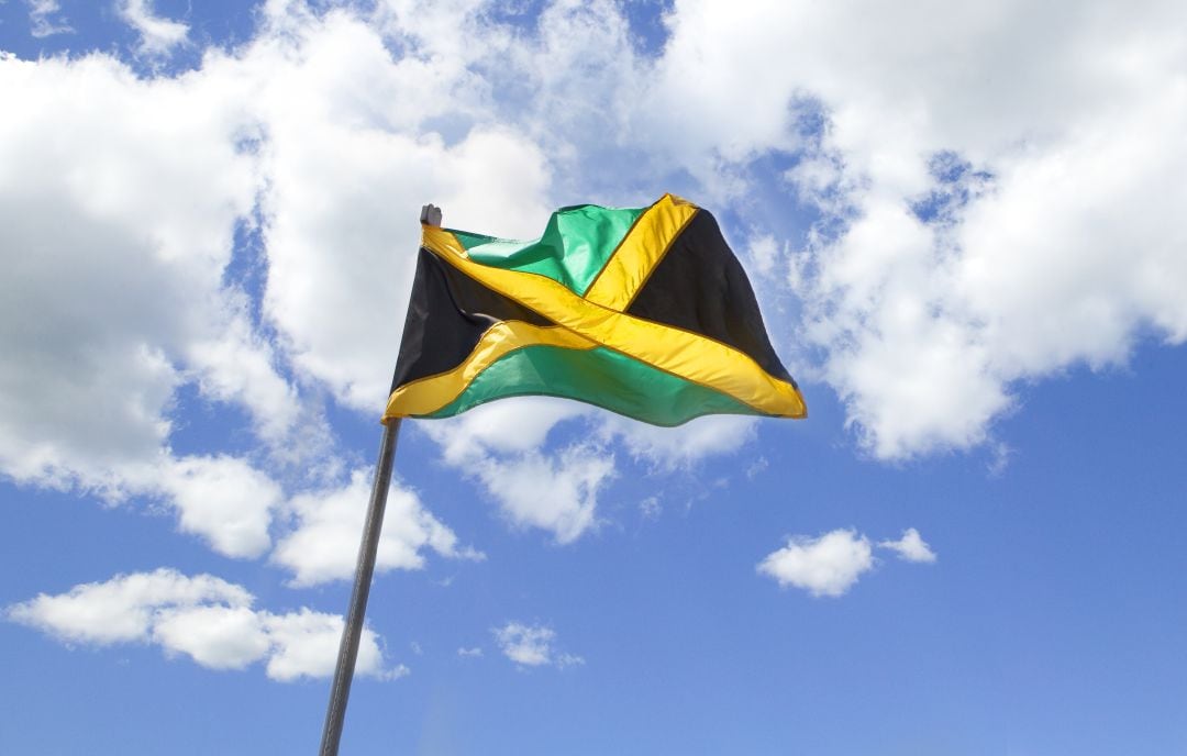 Bandera jamaicana ondeando en un edificio de Kingston 